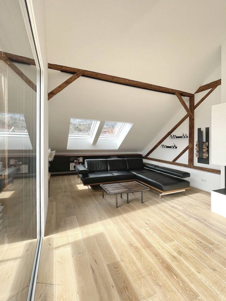 modern eingerichtete Dachgeschosswohnung in Fachwerkhaus, mit freigelegten, sichtbaren Holzelementen.